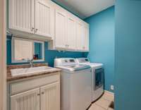 Laundry room with plenty of cabinet space and a utility sink! Washer and dryer can remain if requested