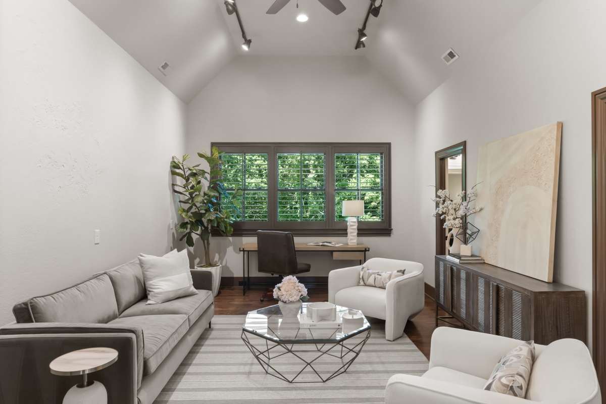 Study overlooking the back yard and woods behind. The door to the back-right is a half bath that has a jack-n-jill connection to the bathroom for bedroom 4. Note the vaulted ceiling and gallery lighting.