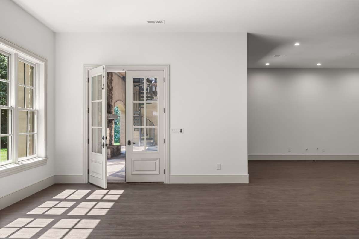 Doors leading to the lower covered patio from the bonus room. Easy access to the future pool. Note the high ceiling.