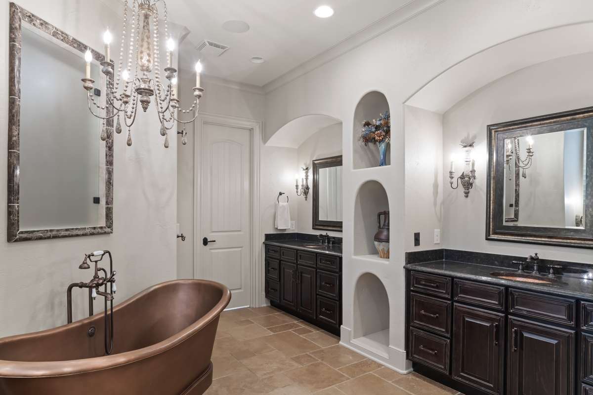 Regal copper slipper tub and separate vanities. Large walk-in closet with built-ins in the background.