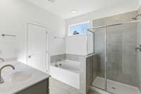 The main-level owner’s suite offers convenience and comfort with a large walk-in closet, separate tub and shower, and peaceful views of the backyard.