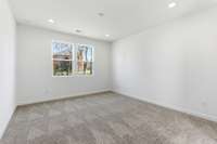 The main-level owner’s suite offers convenience and comfort with a large walk-in closet, separate tub and shower, and peaceful views of the backyard.