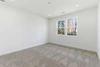 The main-level owner’s suite offers convenience and comfort with a large walk-in closet, separate tub and shower, and peaceful views of the backyard.