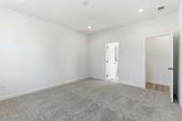 The main-level owner’s suite offers convenience and comfort with a large walk-in closet, separate tub and shower, and peaceful views of the backyard.