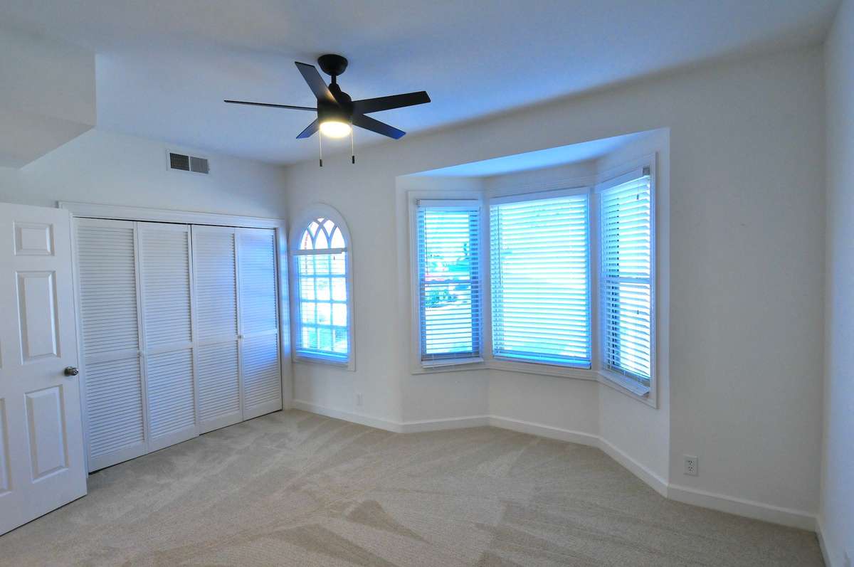 Secondary bedroom features a large closet and a bay window.