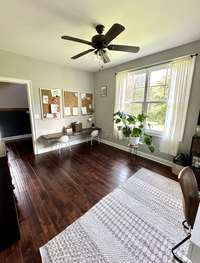 Office/bedroom has hardwood floors and natural lighting.