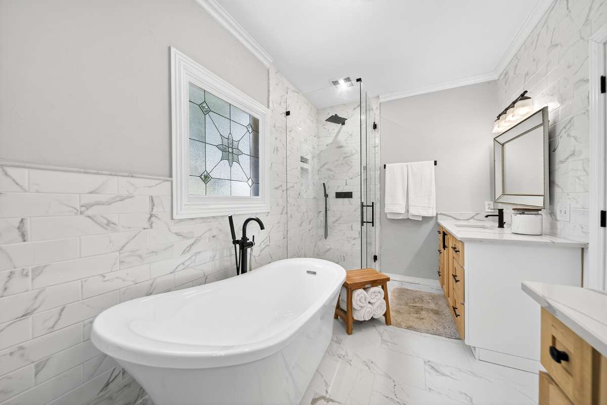A spa-inspired retreat featuring gleaming porcelain floors and walls that exude timeless sophistication.