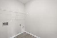 Laundry room is situated off hall across from Primary Suite.