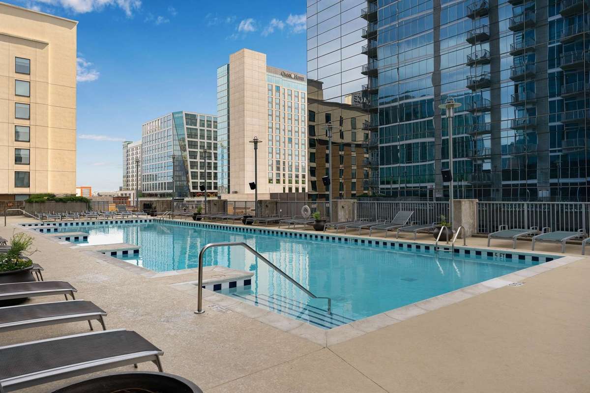 The pool sparkles and is surrounded with plentiful seating, cabanas, a fire pit, and grilling areas.