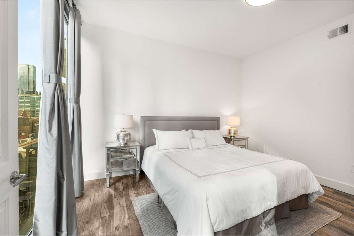 The handsome primary bedroom includes custom drapery.