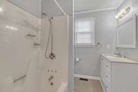 The spacious Bathroom with a Large Vanity and Shower/Tub Combination.