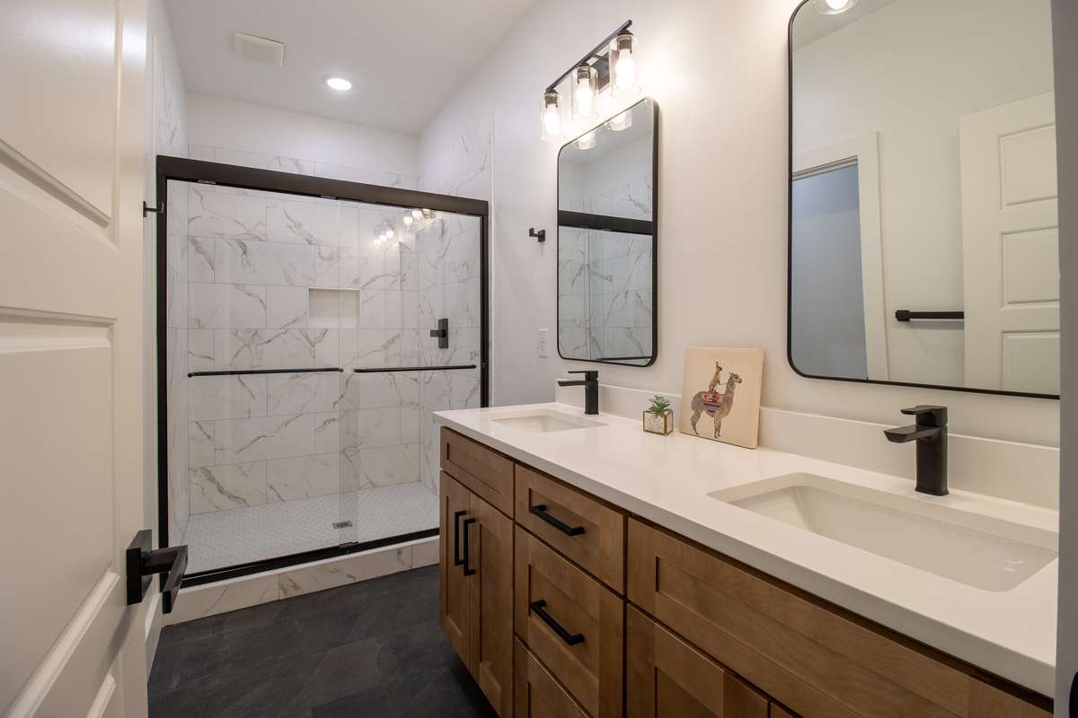 The primary suite has an en suite bathroom with dual sinks and large tiled shower.