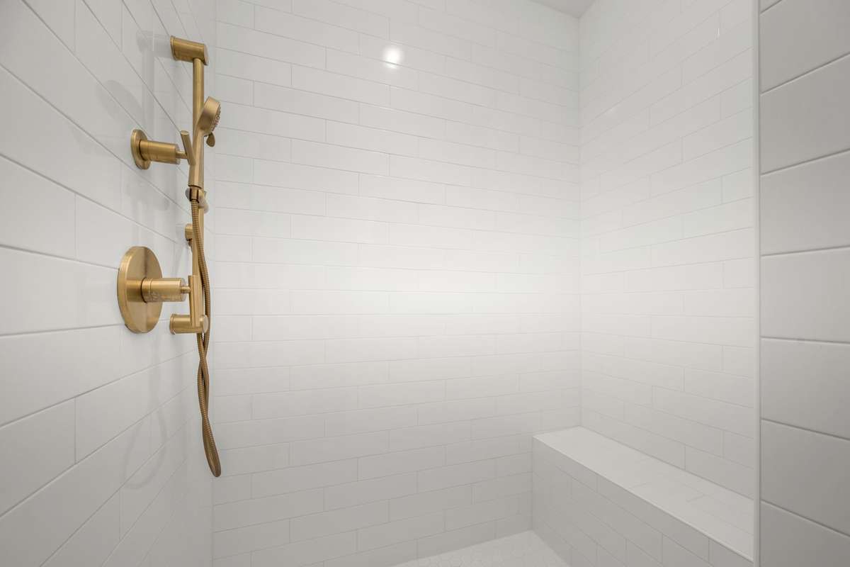 Spa-like bathroom with dual sink vanity, private water closet, and tiled shower with bench seating!