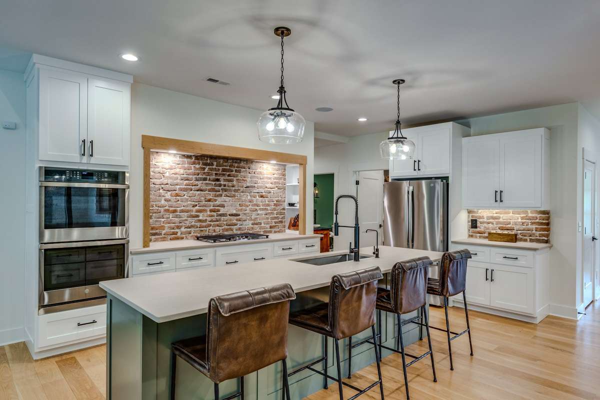 Island bar built-in ovens and Vintage brick backsplash