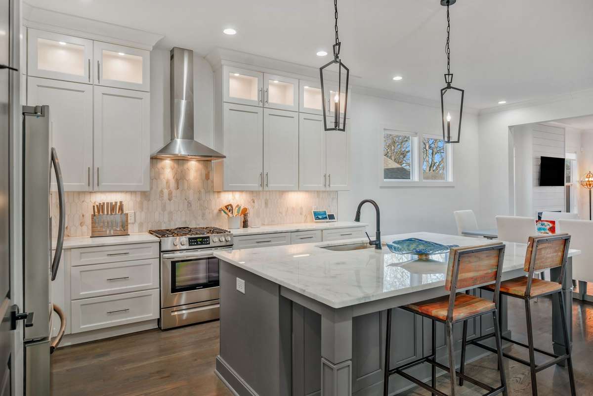 The Gas Range is Vented under counter lights accent the countertops and full backsplash Island has hidden storage under seating area