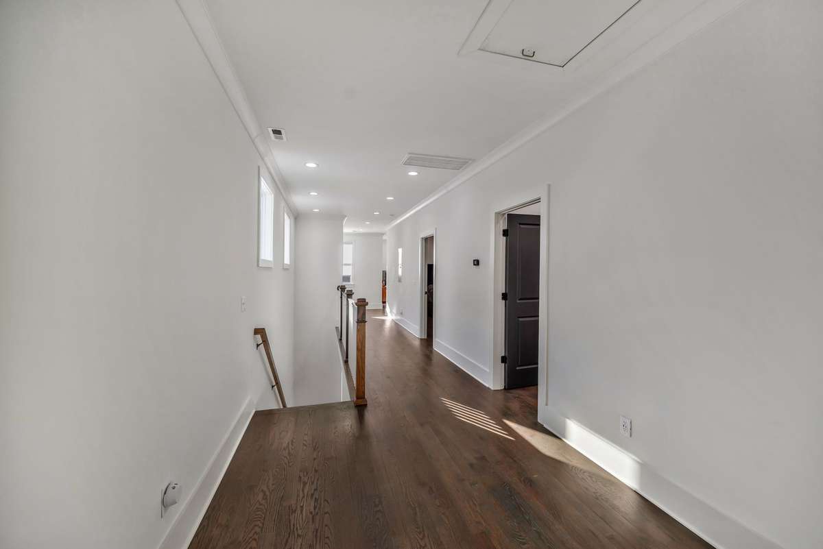 Upstairs Central Hallway w Hardwood Floors and Abundant Windows Allow Natural Light to flow into the hallway and staircase