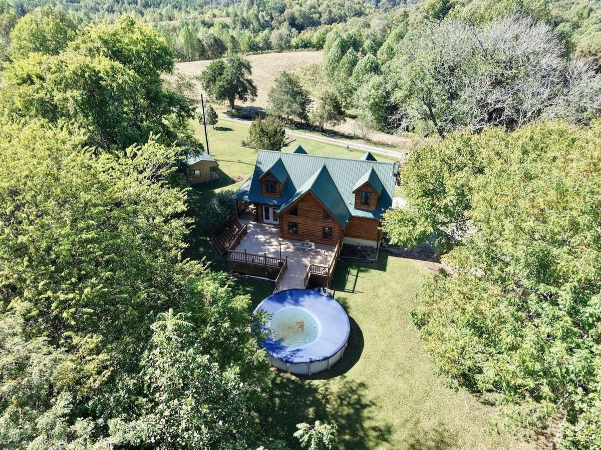 View of rear of home.  Back deck overlooks above ground pool.