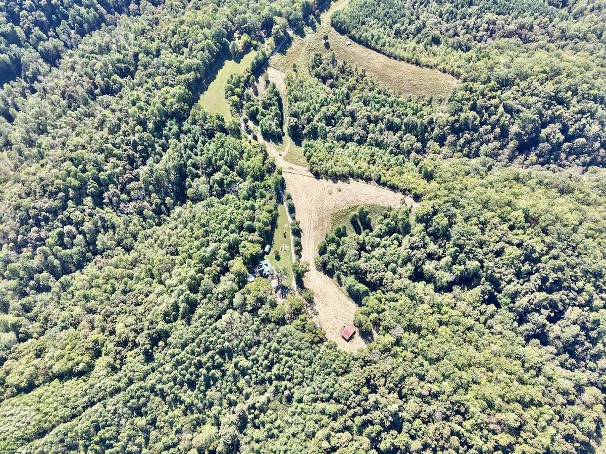 Drone view of property - notice the trail leading out the ridge behind the home.  Great for walking, hiking or horseback riding!