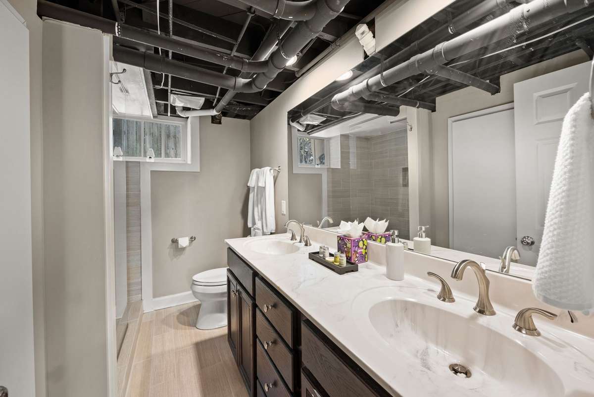 The basement bathroom has dual vanities and a walk-in shower.