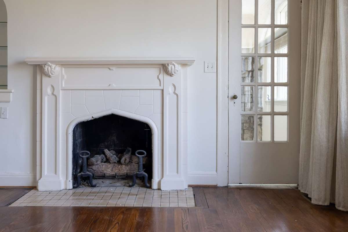 An elegant fireplace mantle serves as the focal point of the space, with a French door allowing a sightline into the bonus space.