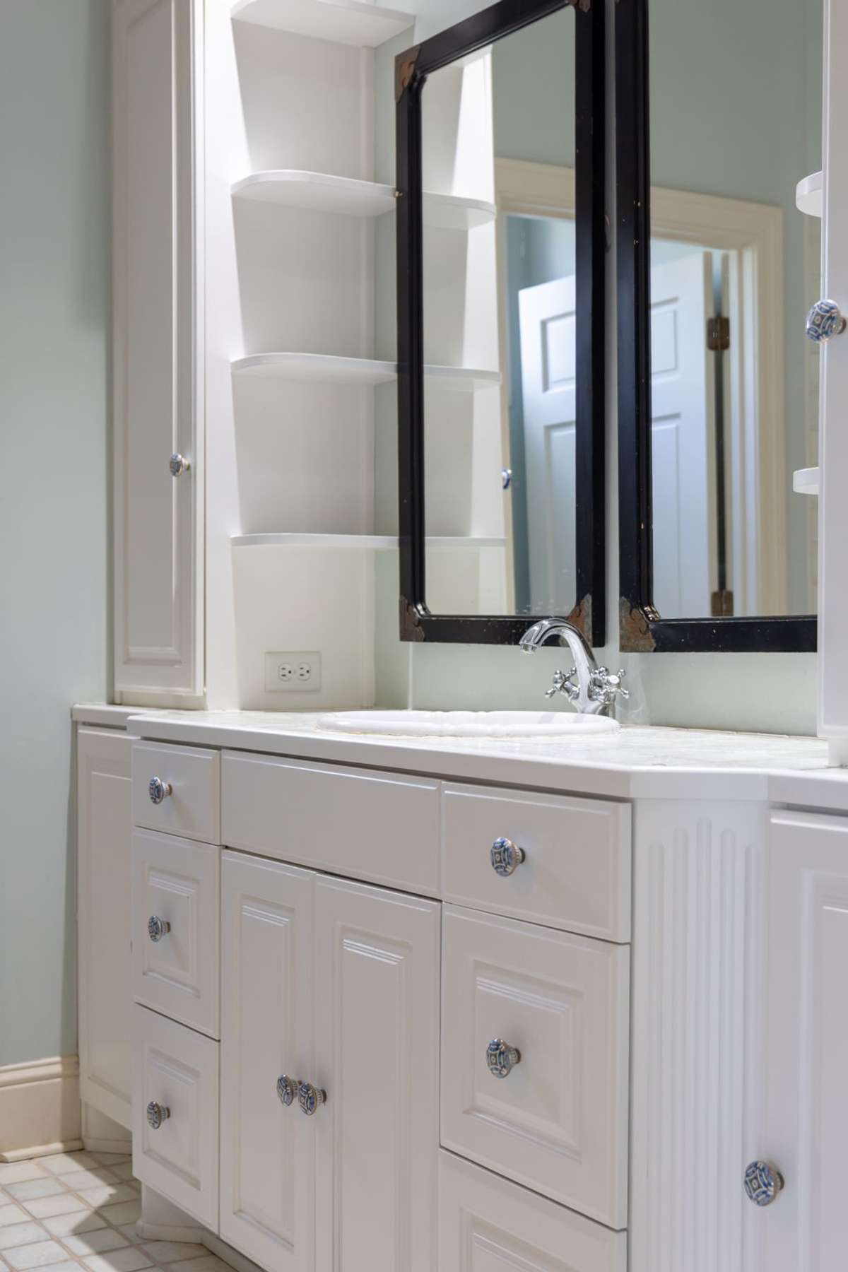 A closeup view of the vanity showcases abundant storage, double mirrors, and functional shelving