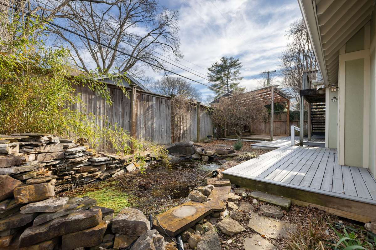 Stone water feature/pond adds a unique focal point to the backyard and enhances the serene setting.