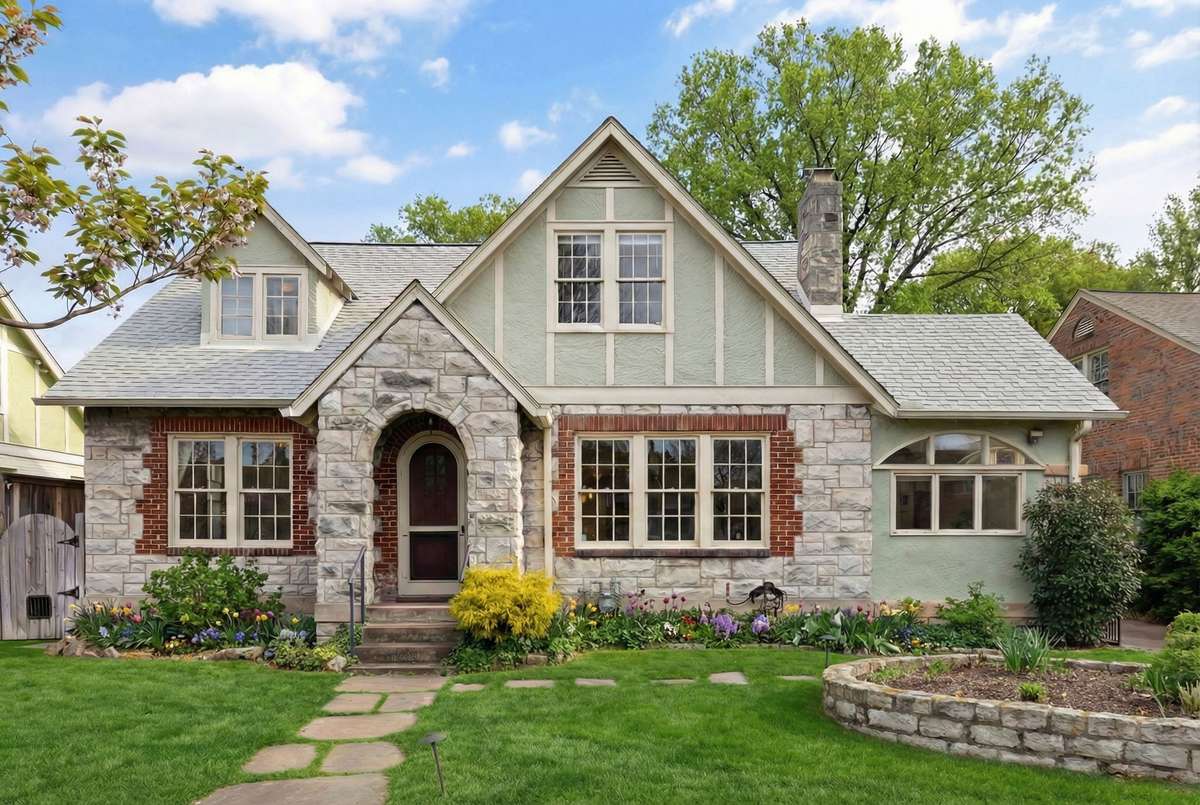 Elegant front elevation highlights the home’s steep gables, stonework, and expansive windows that flood the interior with natural light. *Exterior landscape digitally enhanced.