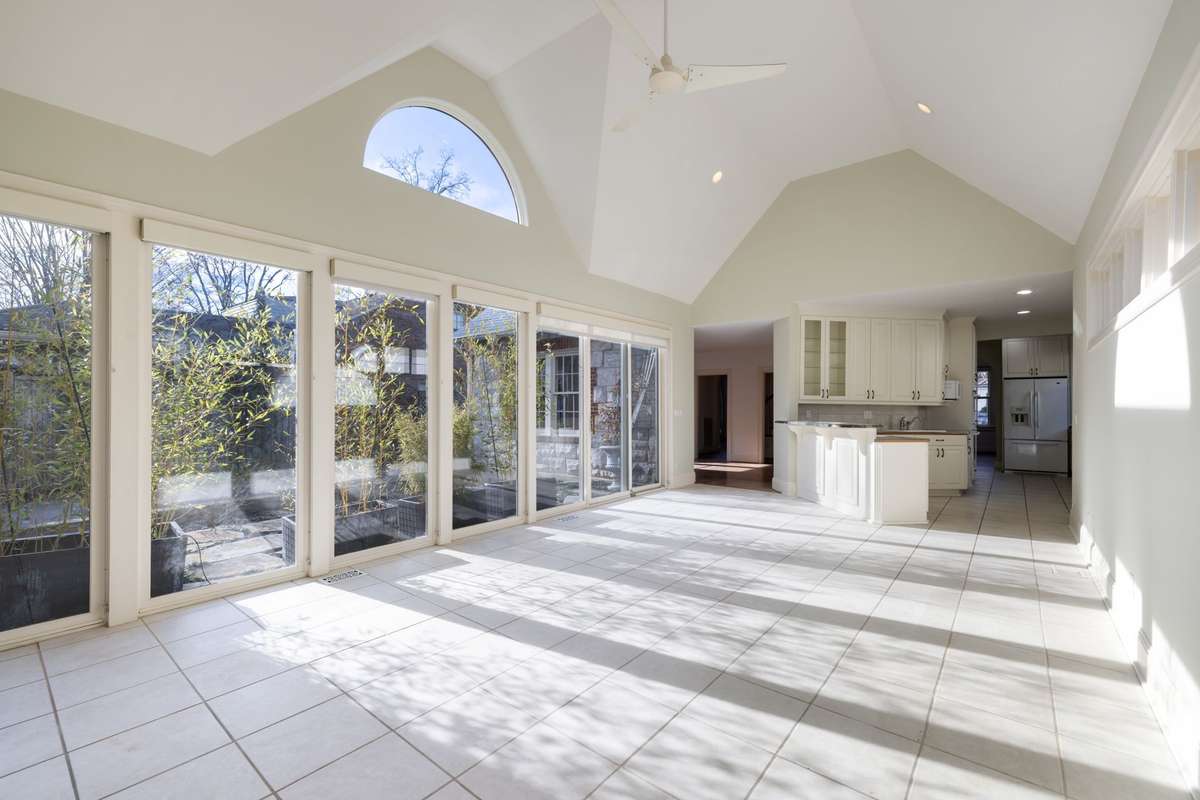 Open-concept sun room connects effortlessly to the kitchen, offering generous space for casual dining, entertaining, or a secondary living area.