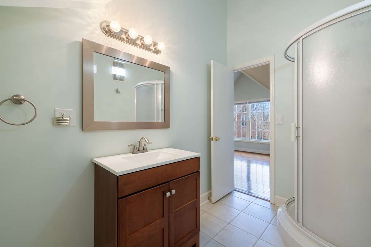 Updated vanity with modern lighting and mirror, offering a clean, functional layout with easy access to the main living area.