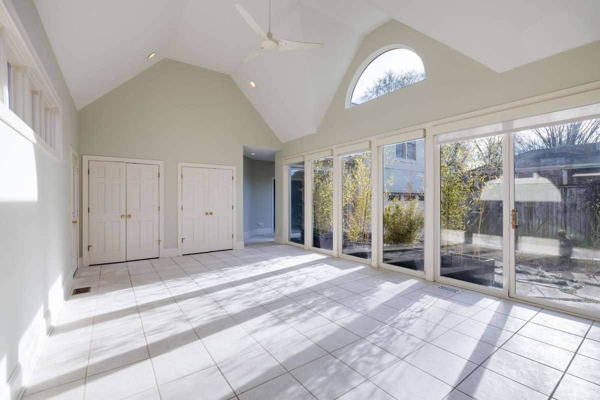Vaulted ceilings and walls of glass create a bright, open atmosphere with direct access to the courtyard and seamless indoor-outdoor flow.