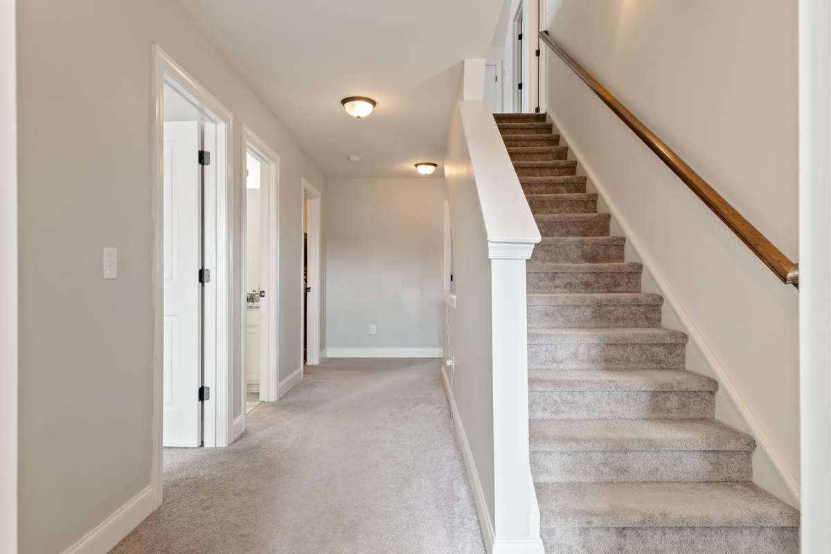 This hallway photo illustrates the doors to the second and third bedrooms. The second full bathroom door is the middle door pictured.