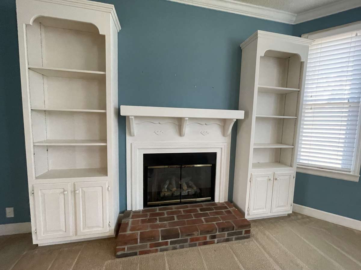 nice fireplace with a mantel and built-in book shelves