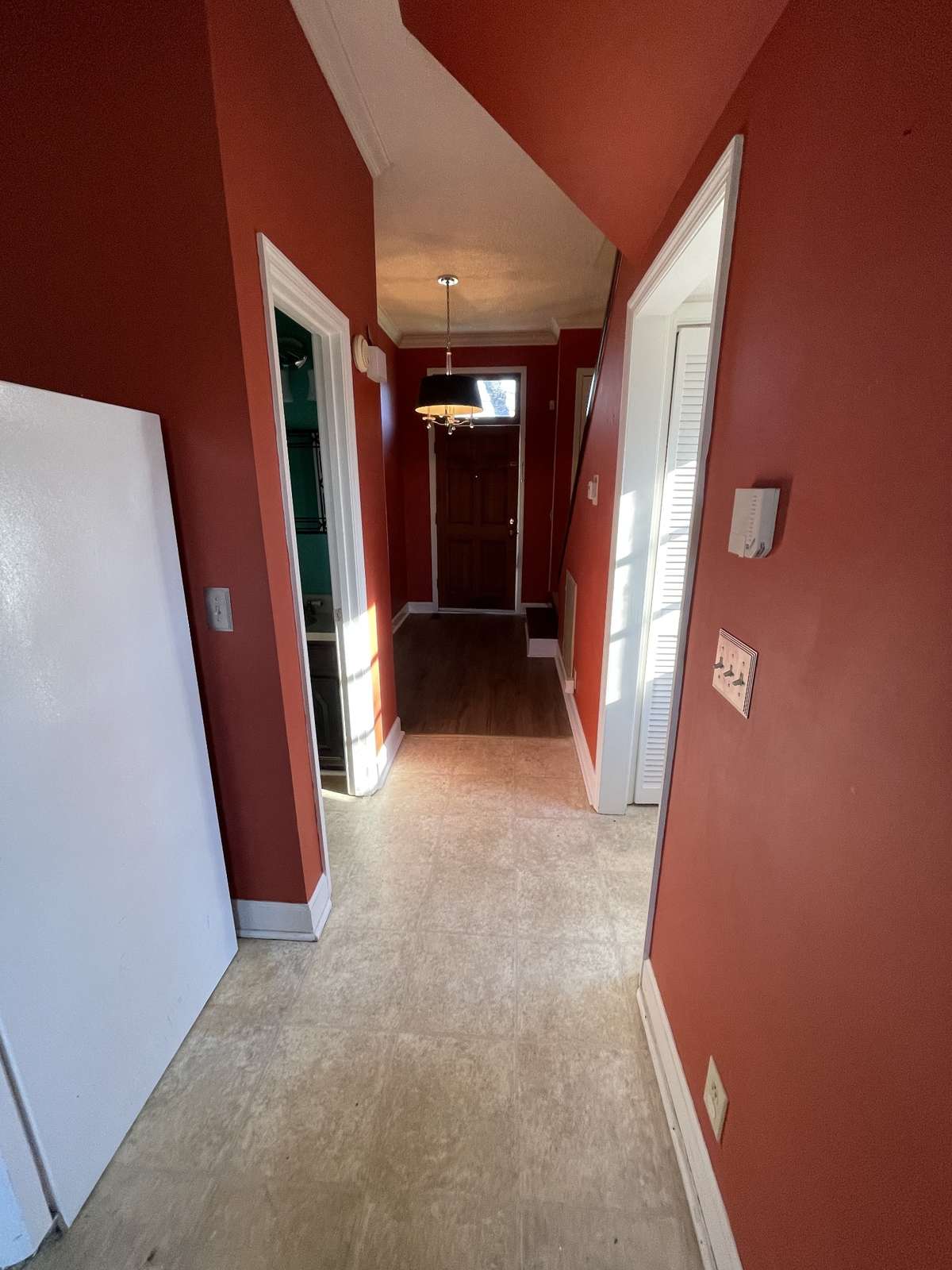View from Kitchen into the foyer, with half bath on the left, side door on the right with washer and dryer hook ups