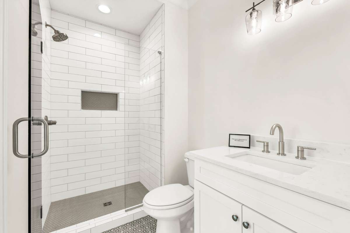 Full bath located on the maim level with custom tile floor and tiled shower