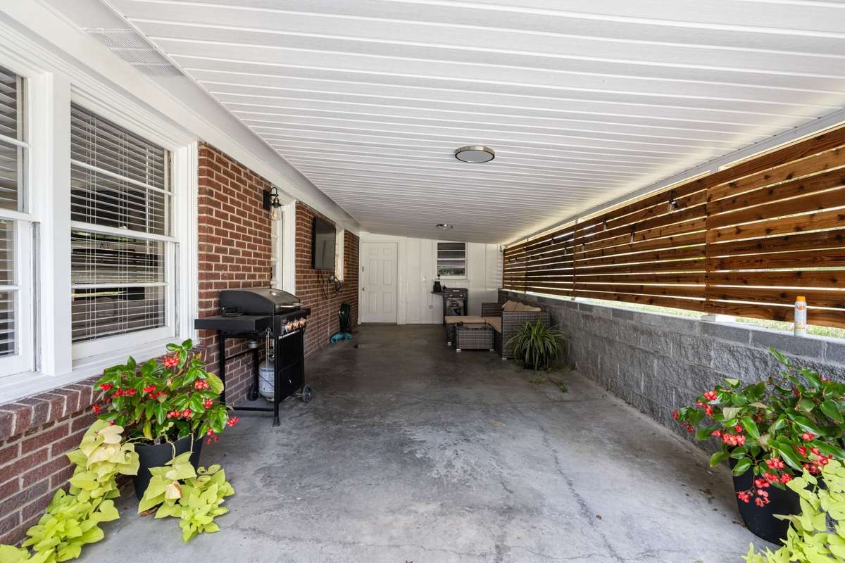Covered patio with wood privacy accents, ideal for outdoor seating and entertaining