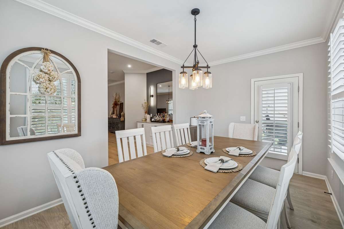 Formal dinning room with custom window treatments. Wooden built in shades. Bottom shade operates separately for privacy while allowing in natural light