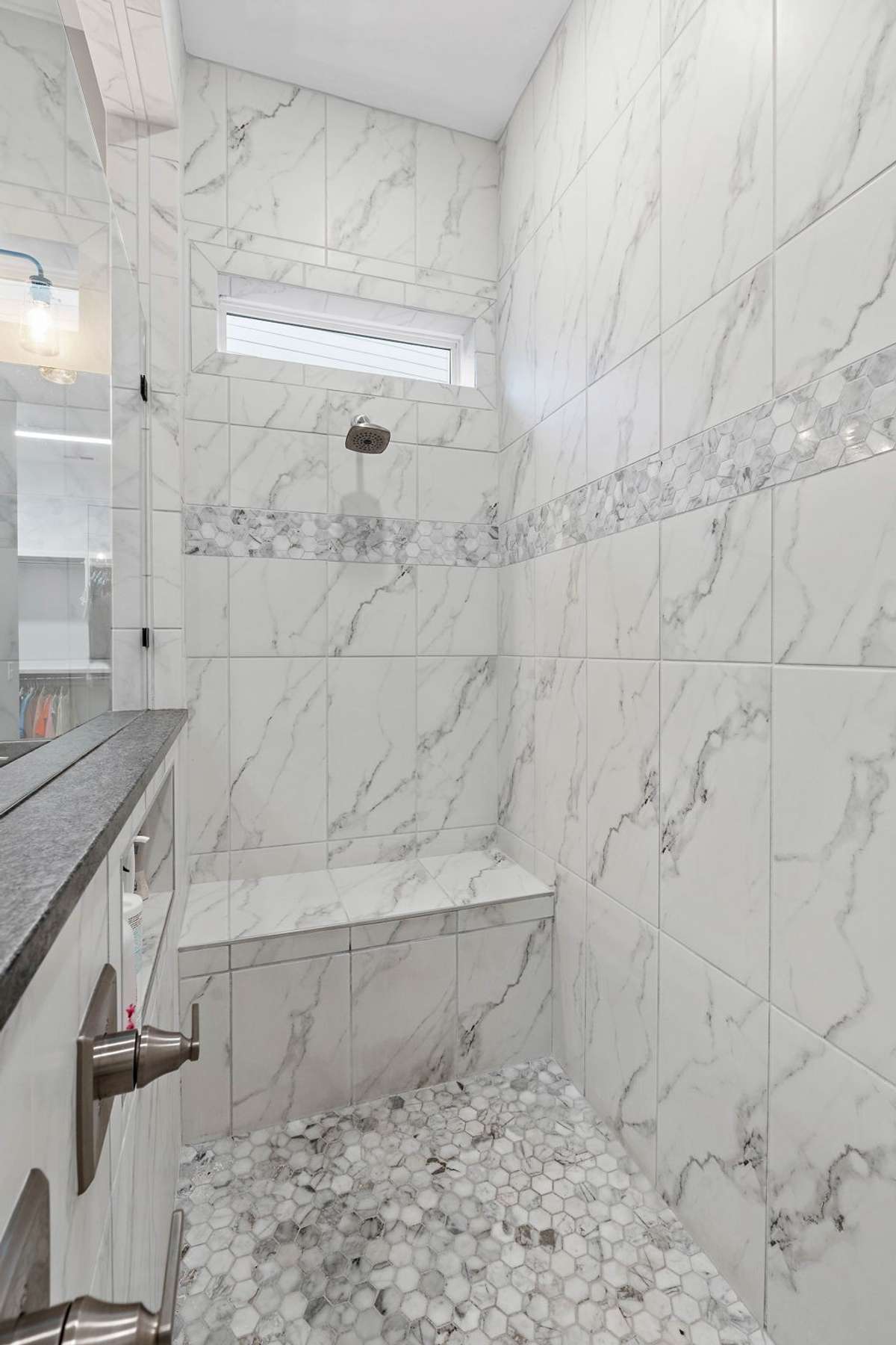 Luxury shower with two shower heads, sitting area and place to store all your shampoo