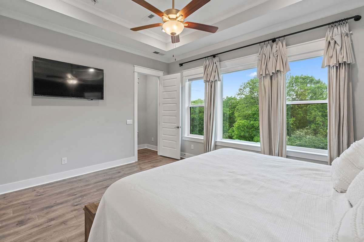 View from the primary bedroom to the tree lined backyard