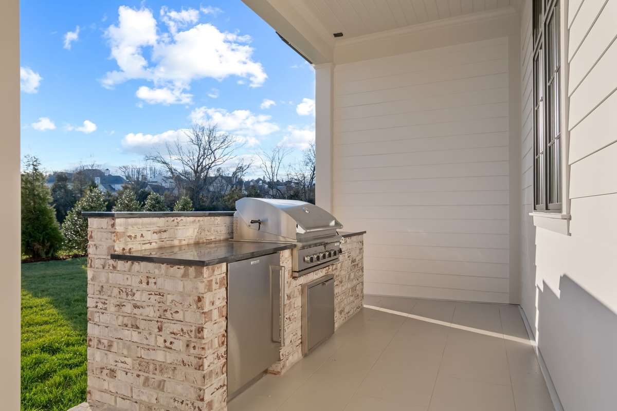 Rear porch is perfect for outdoor dining, living, and grilling