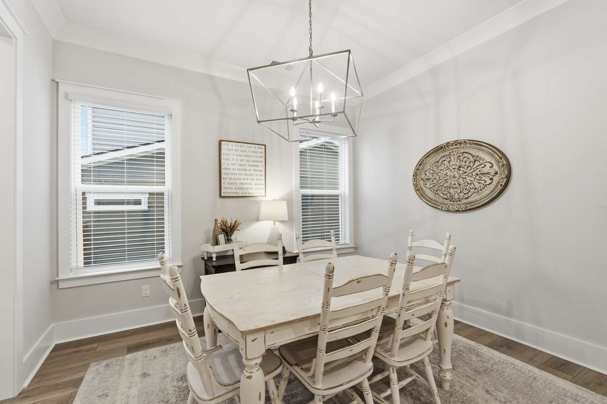 In the dining room, picture windows and a timeless hanging light fixture create the perfect place to enjoy dinner or your morning coffee while watching the sunrise or sunset.