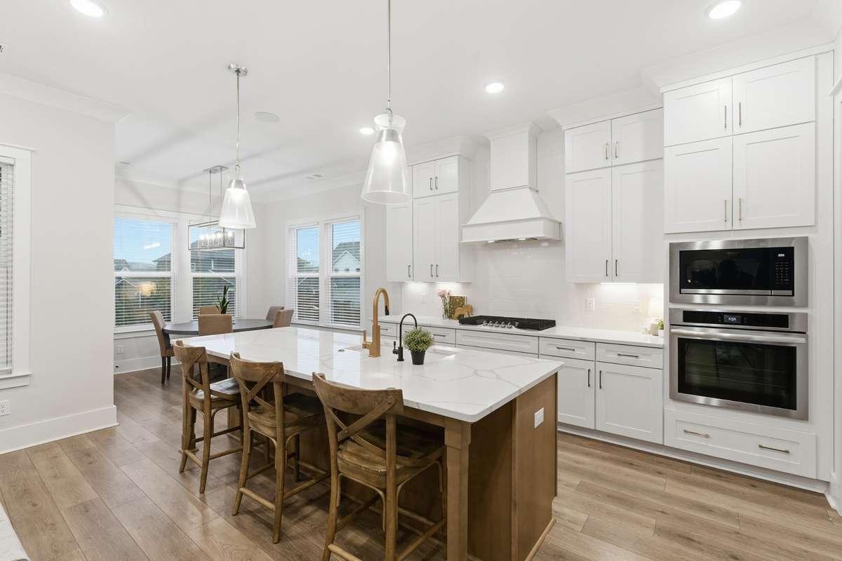 Large picture windows surround the seating area in the kitchen allowing for natural lighting to enter the home and add warmth to the ambiance of the room. Mixed with the wooden accents create a relaxing and inviting area for families and friends.