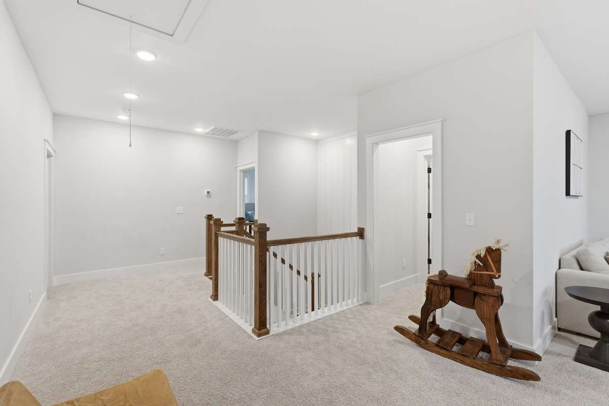 The expansive and brightly lit bonus room, featuring multiple windows, recessed lighting, a neutral color palette offers incredibly flexible living space that can adapt to various needs.