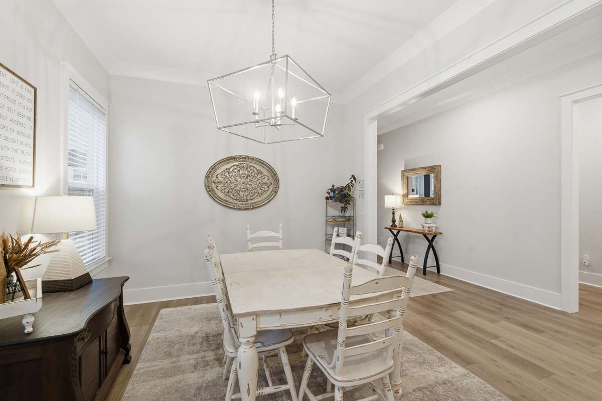 In the dining room, picture windows and a timeless hanging light fixture create the perfect place to enjoy dinner or your morning coffee while watching the sunrise or sunset.