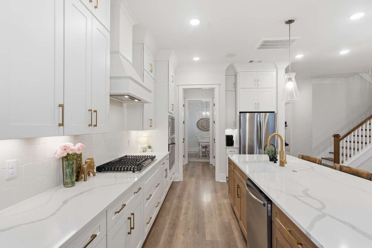 Within steps, you will enter the crisp and beautiful kitchen. It truly is a chef's dream. Complete with overhead lighting, a full island area with SS appliances, a stunning cookstove top, double-ovens and so much more...