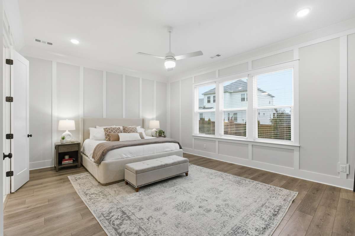 The primary bedroom is beautifully adorned with white trimmed wall accents and an upgraded ceiling fan for added comfort.