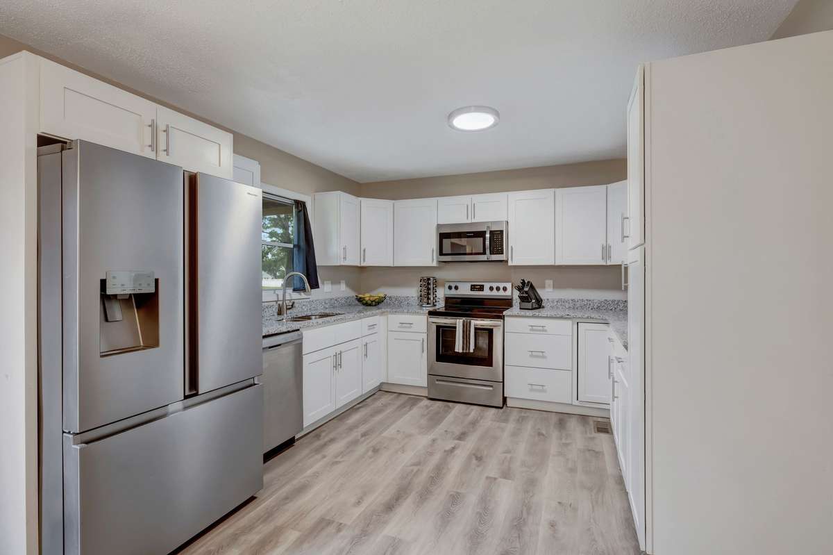 Kitchen has been fully renovated with stainless appliances, white shaker cabinets and granite counters