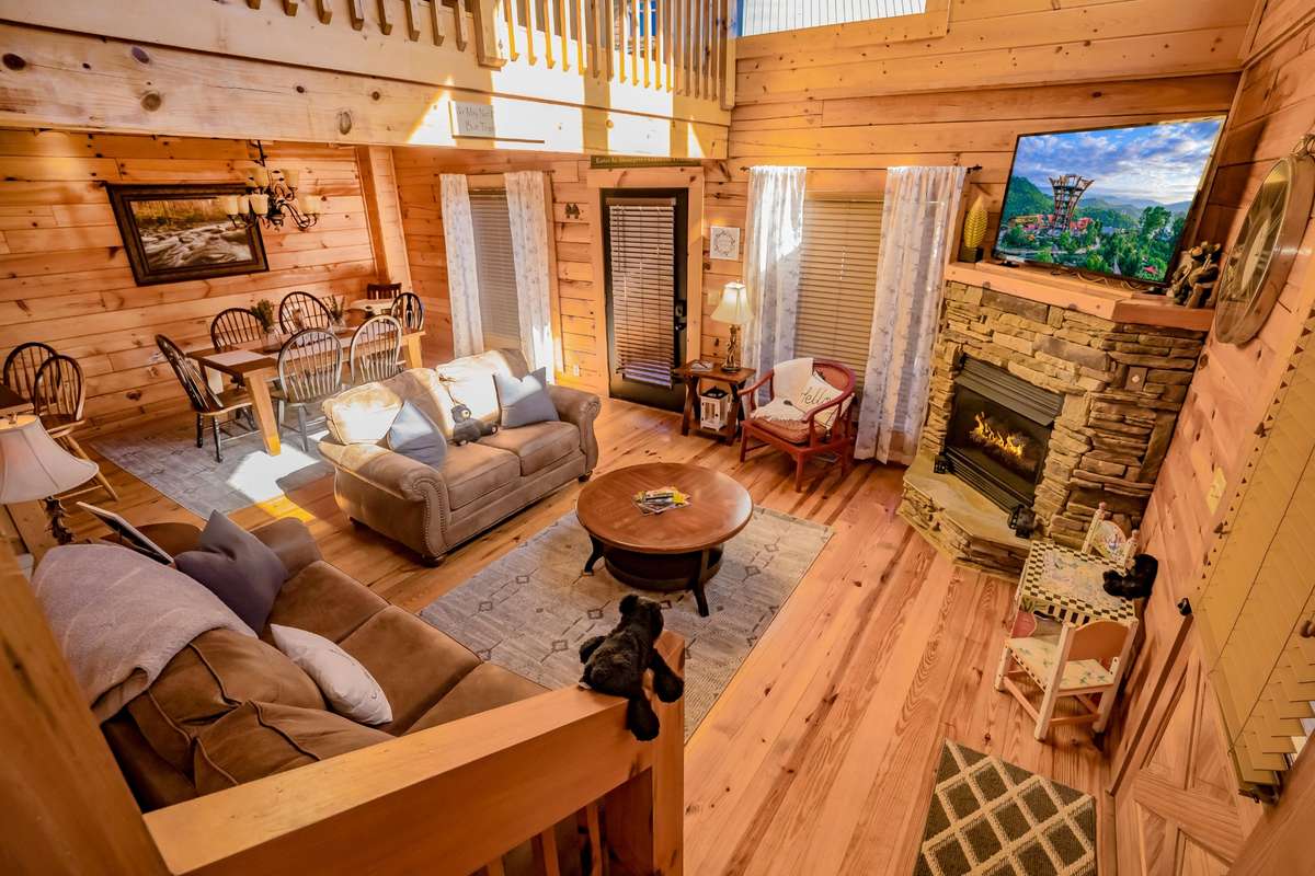 Open floor plan with gas stone fireplace, 55" smart tv, furniture and access to the covered porch.