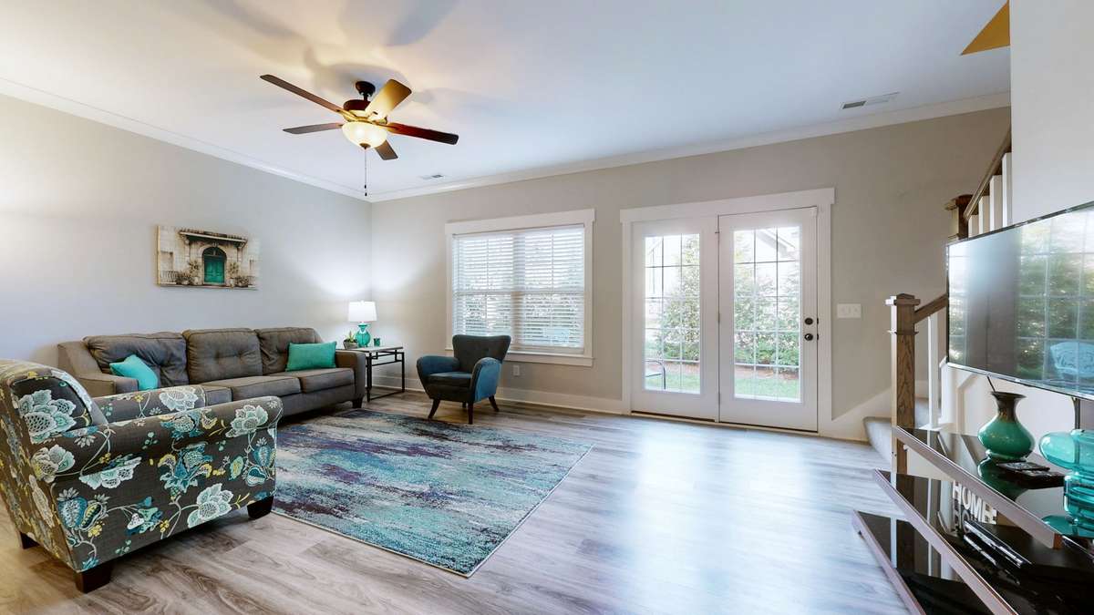 Crown molding, ceiling fan and lots of light from the back of the townhouse.