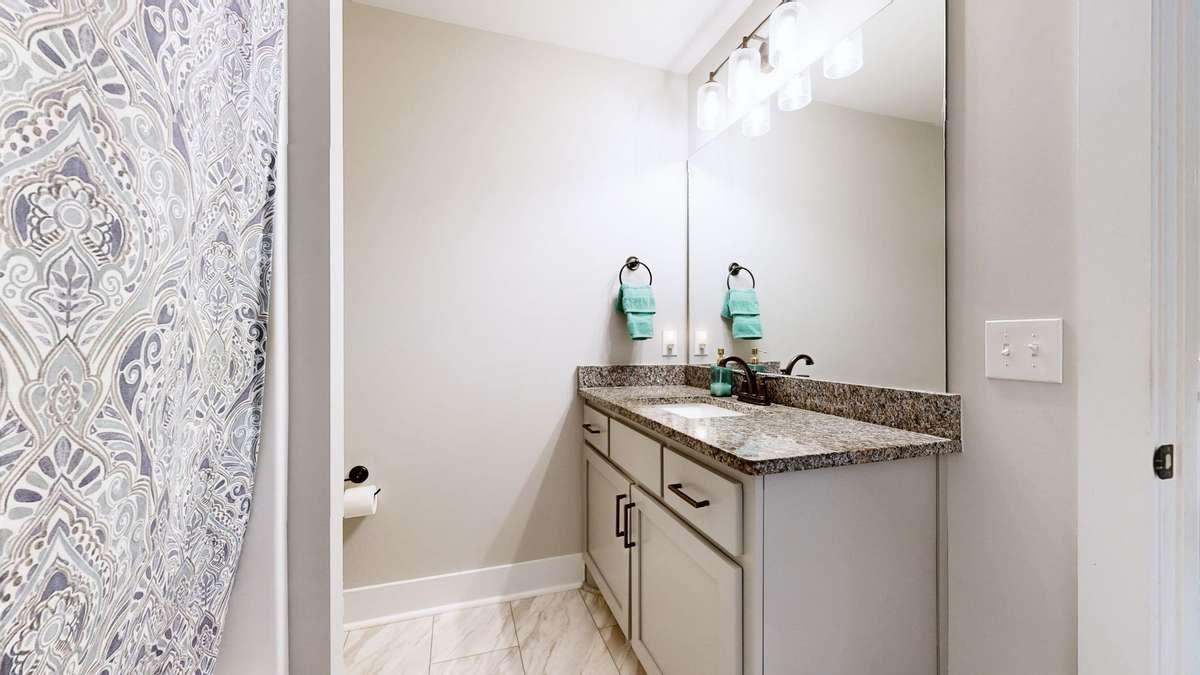 Guest bathroom with granite, tile and tub/shower combo.
