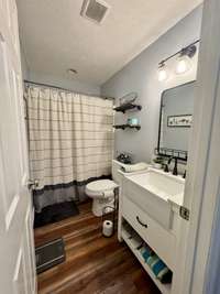 Hall bathroom with updated fixtures, note the farmhouse sink .